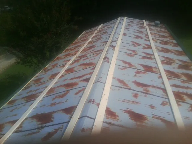 Rusted metal roof panels with new wood purlins before replacement — Storm Damage Roof Repair in Bennettsville by Roofing Brothers