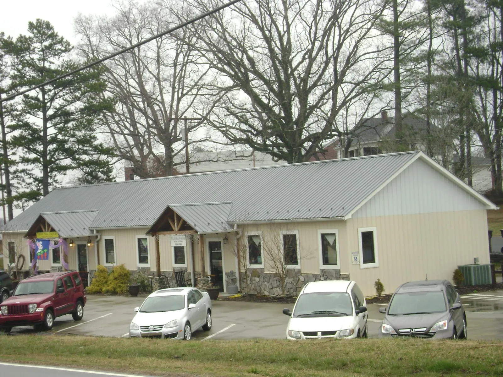 Gray metal roof with timber entry brackets on a small commercial building in Bennettsville