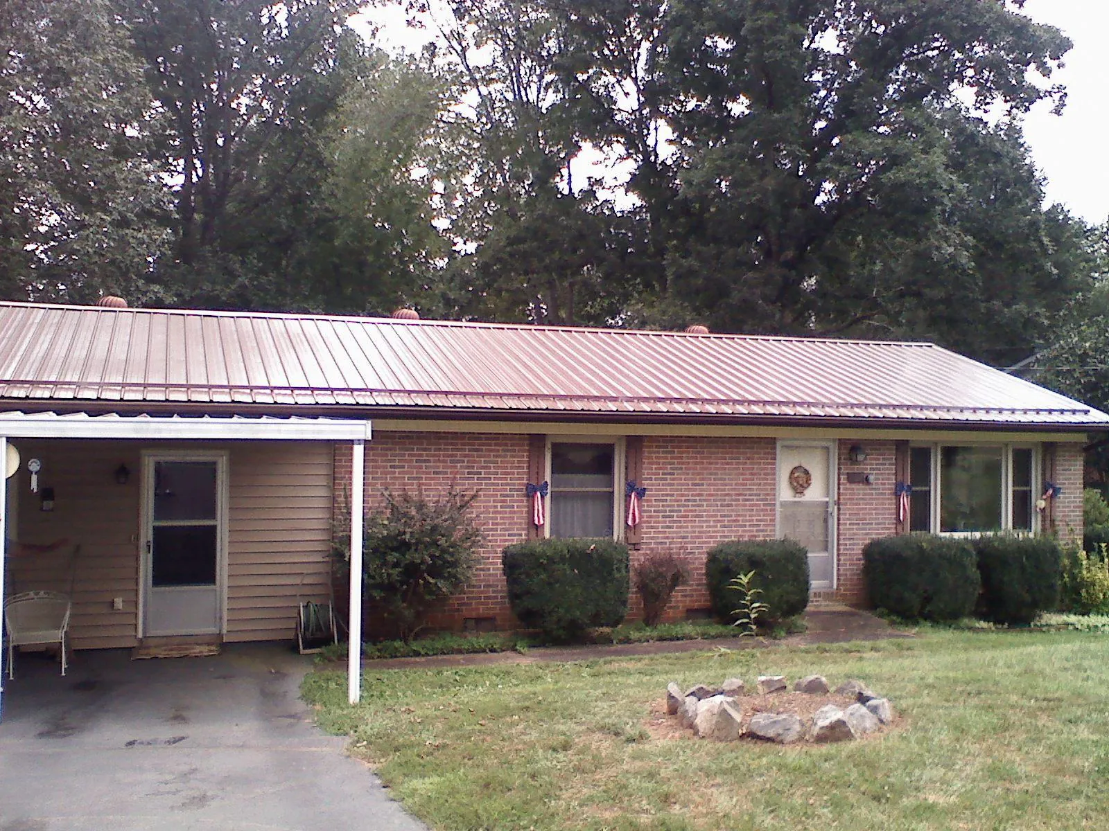 Bronze metal roof and carport on a brick ranch home — Roof Repair work by our crew in Bennettsville